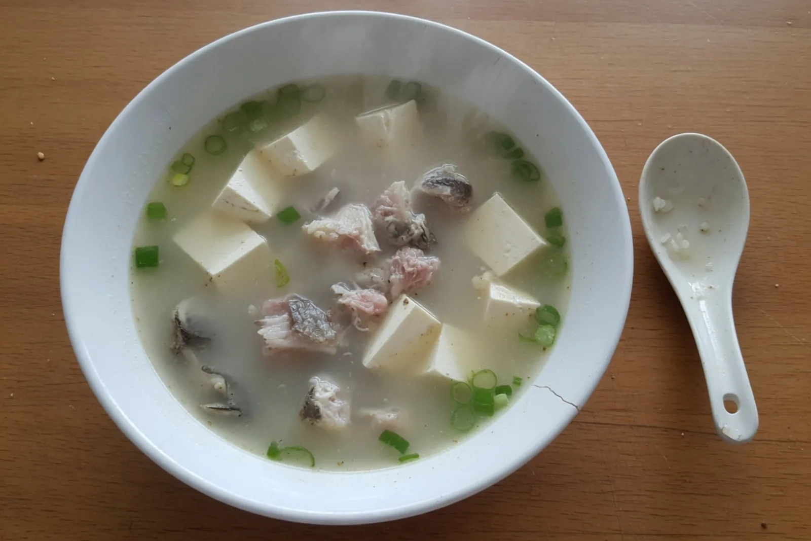 一碗家常鲫鱼豆腐汤，鱼肉和豆腐都在汤里。